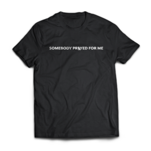 Black Christian t-shirt with white text reading “Somebody Prayed For Me” and praying hands design
